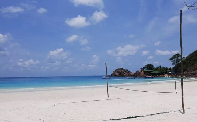 pulau redang white sandy beach and clear blue seawater under cloudless sunny blue sky