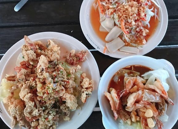 热浪岛餐桌上供应令人垂涎的海鲜菜肴炸虾和 somtam