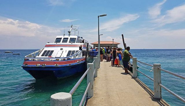 tourists boarding ferry on tioman island jetty