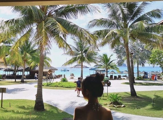 back view of a woman standing at redang laguna resort garden looking at redang sea