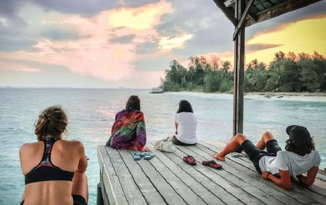 tourists in pulau besar island watching sunset from the deck