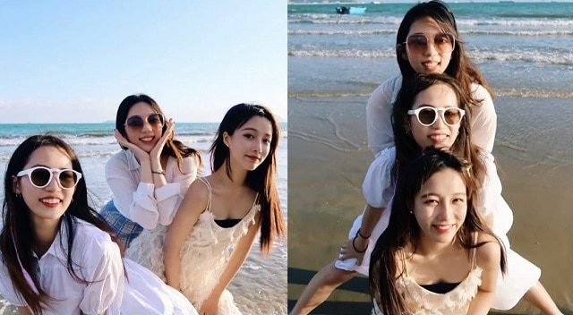 three women standing on beach taking group photos in an island trip
