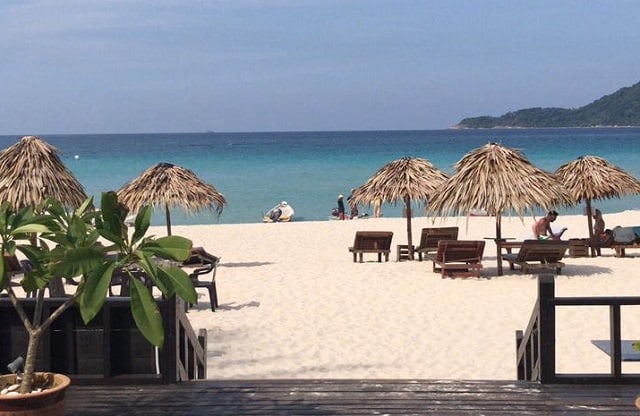 several big straw umbrellas on beach access to perhentian sea