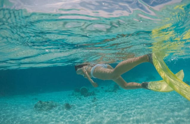 停泊岛穿着黄色脚蹼的女人在浮潜