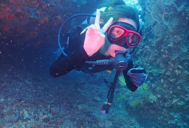 woman with diving equipment diving in pulau tioman island deep sea