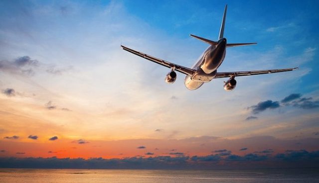 一架飞机在飞往热浪岛的途中和海上的橙色日落
