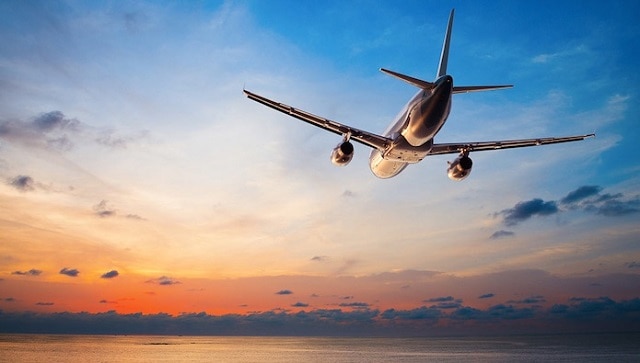 一架飞机在飞往热浪岛的途中和海上的橙色日落