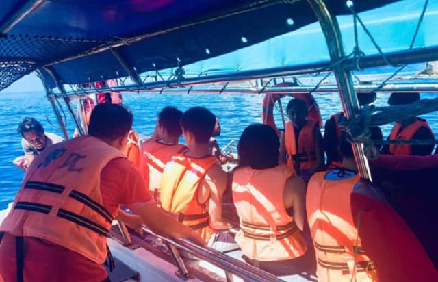 热浪岛快艇上的游客穿着救生衣前往浮潜点进行浮潜