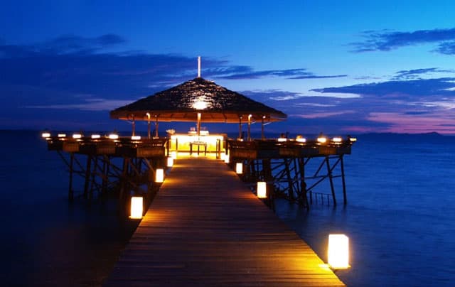 romantic setting of lights along side wooden bridge on pulau tioman island at night
