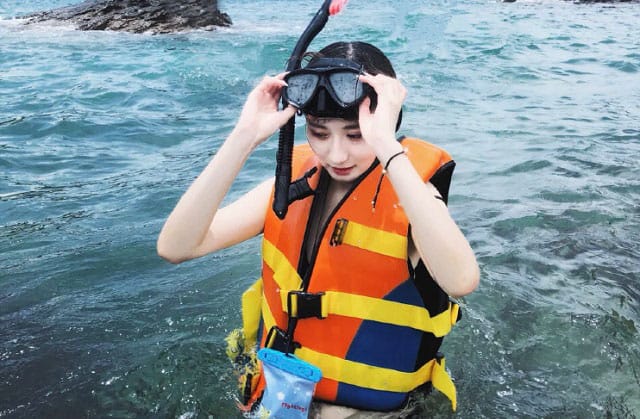 刁曼岛穿着救生衣和护目镜在海洋公园准备浮潜的女人