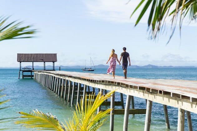 couple walking on bridge of pulau besar island