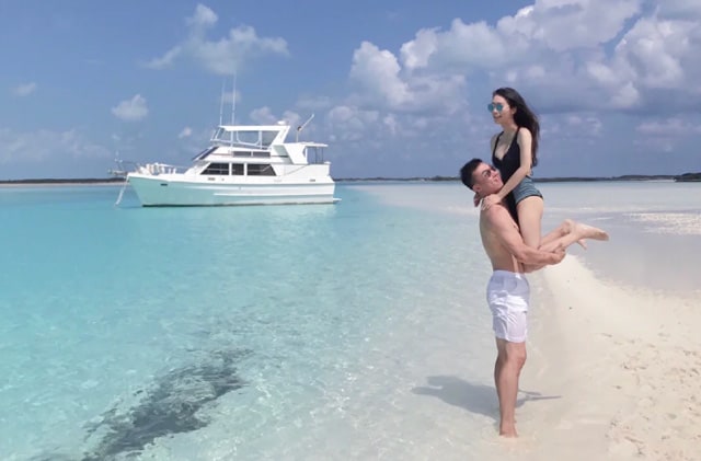 伯沙岛男人抱着他的女朋友膝盖站在海滩上