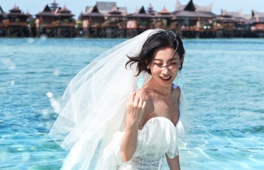 woman wearing wedding veils in front of pulau besar seawater