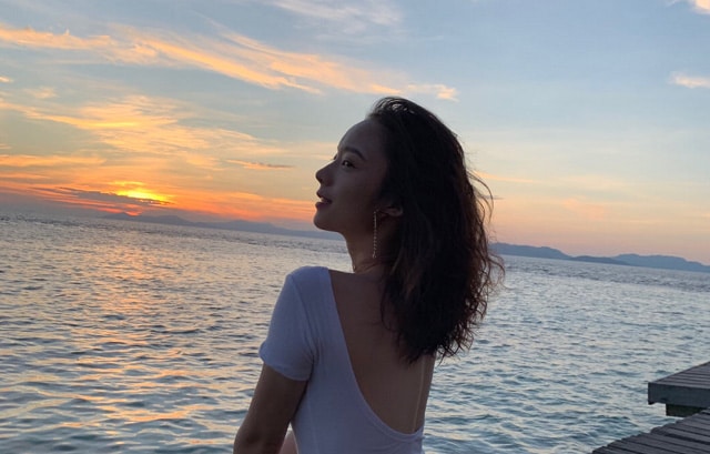 back view of woman in shirt curly hair at sunset of pulau besar