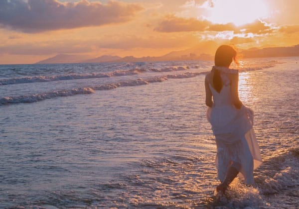 woman standing on beach at sunset in tinggi island