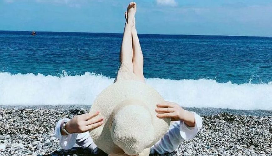 女人躺在丁宜岛的海滩上，双腿指着天空