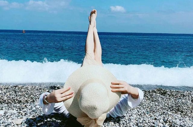 女人躺在丁宜岛的海滩上，双腿指着天空