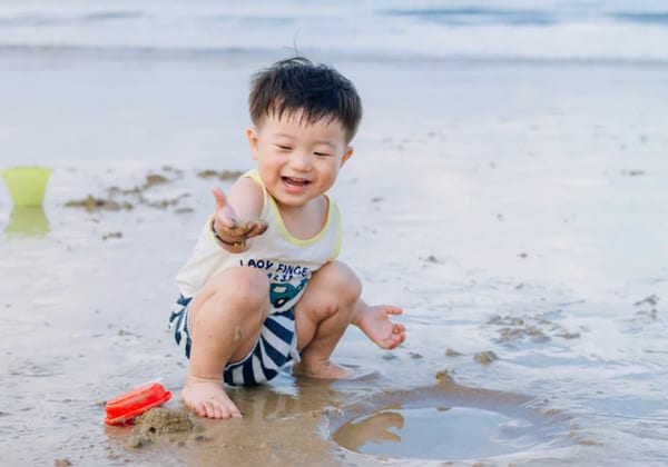 boy playing sands on beach of aur island