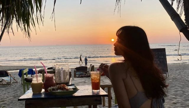 girl sitting on beach of koh lip island watching stunning sunset