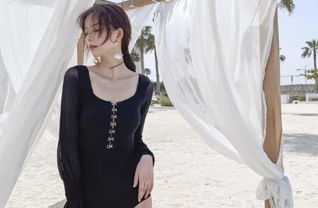 丽贝岛女身穿黑色泳衣站在海滩上