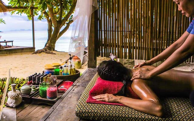 woman having oil massage at beach of koh lipe island