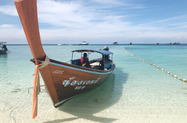 close up shot of long tail boat resting on beach of koh lipe island