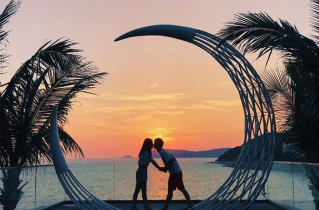 天鹅岛日落时分一对情侣站在海滩接吻的剪影