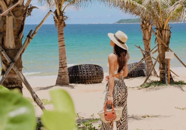 天鹅岛拿着竹袋的草帽女人站在海滩上