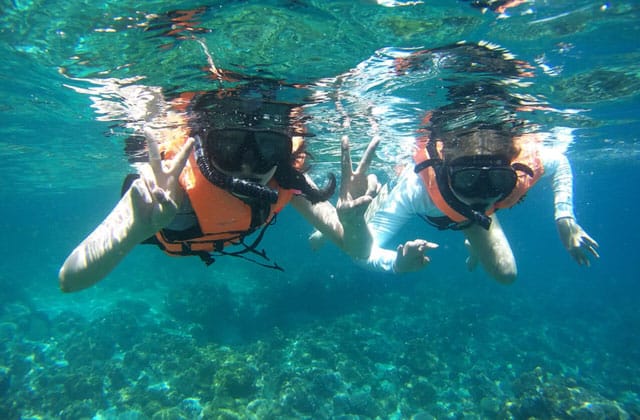tourists snorkeling at koh lipe island clear sea