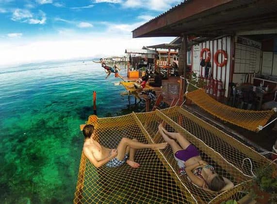 tourists lying on net above sea of scuba jeff guest house in mabul island