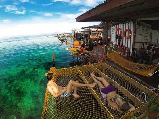tourists lying on net above sea of scuba jeff guest house in mabul island